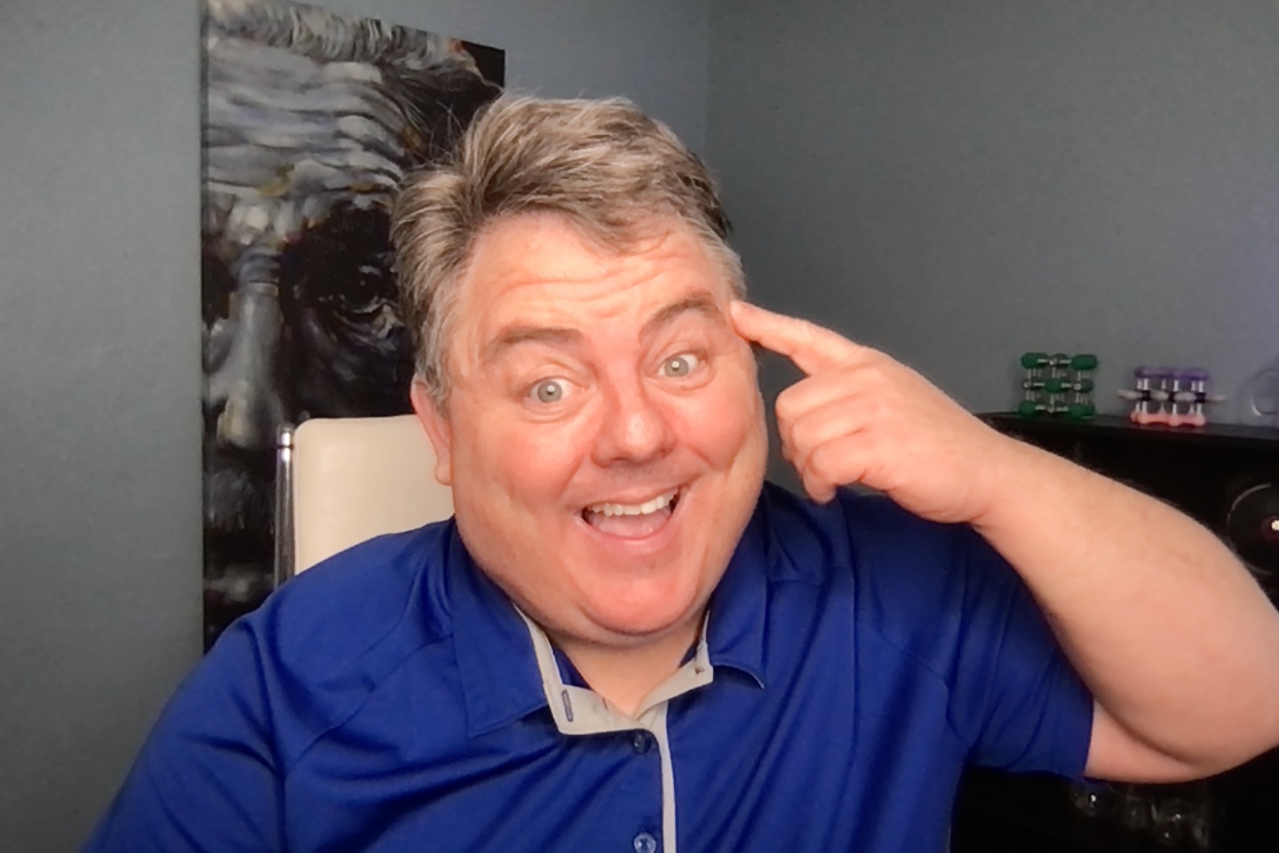 Dr. Chad Wallace grinning and pointing to his temple